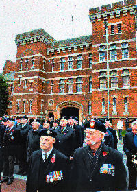 The veterans parade on the road beside the memorial
